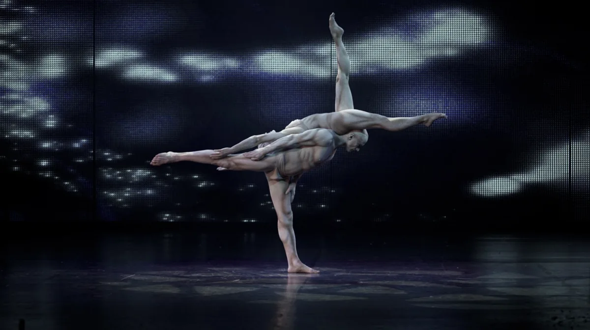 Circo contemporaneo: performer in scena davanti a una proiezione